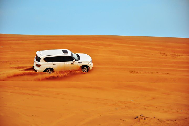 Experience the beauty of Dubai's red dunes as you embark on an exhilarating ride skimming across golden sands while enjoying breathtaking desert views and the thrill of adventure.